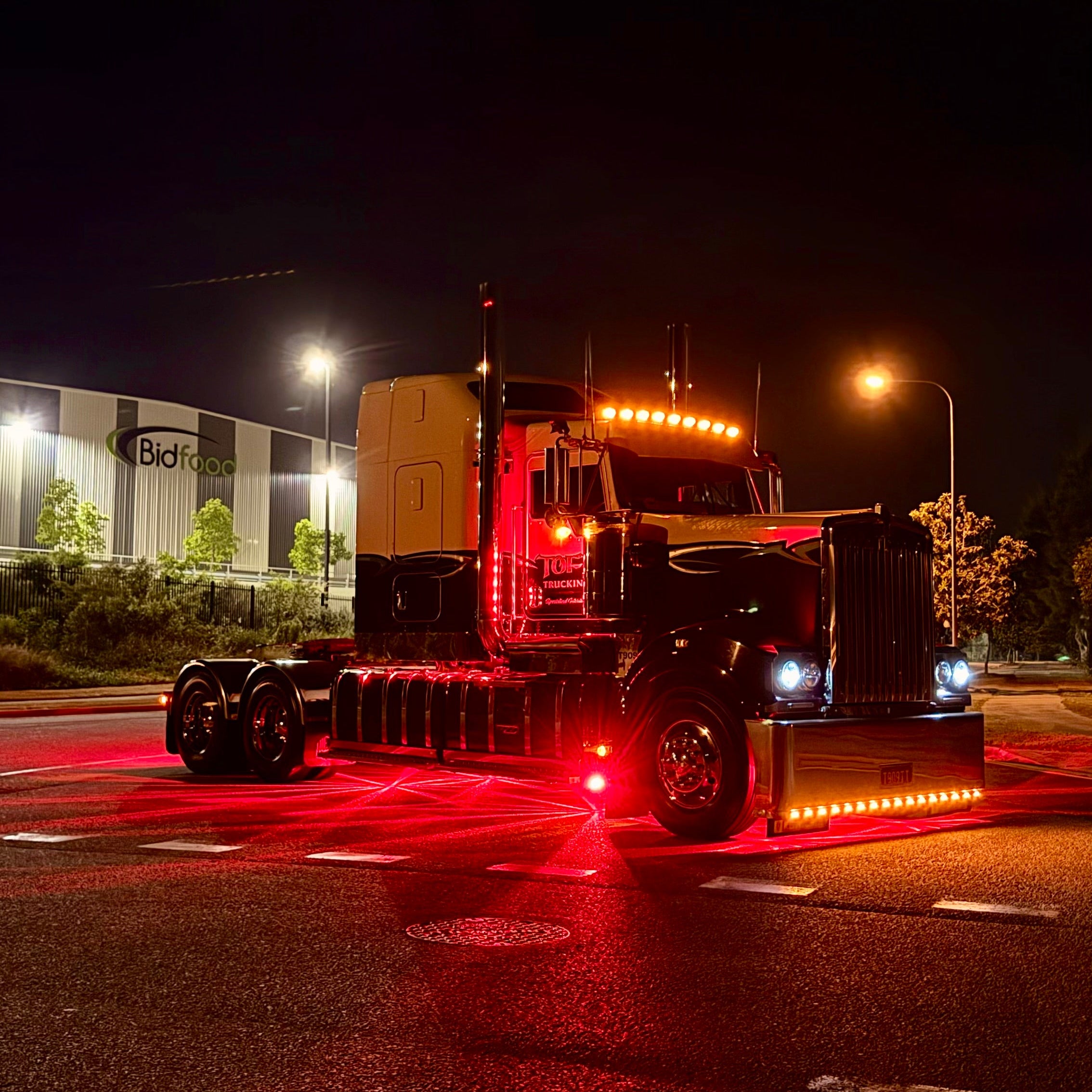 Kenworth T909 fitted with glass watermelon LED underglow lights illuminated in red at night